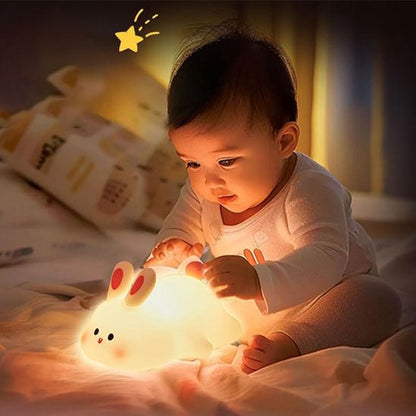 bébé touche la veilleuse lapin